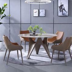 a round table with four chairs around it in a modern dining room setting, surrounded by plants and pictures on the wall