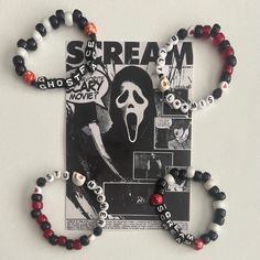 a bracelet with beads and magnets attached to it on a white surface next to a poster