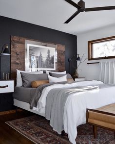 a bedroom with a large bed and wooden headboard on top of a rug in front of a window