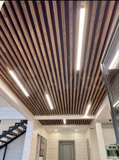 the inside of a building with wood slats on the ceiling and stairs leading up to it