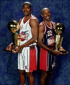 two basketball players holding trophies in their hands