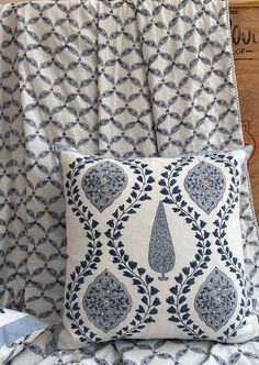 a blue and white pillow sitting on top of a bed