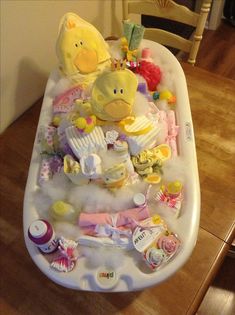 a baby bath tub filled with toys on top of a wooden floor