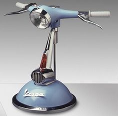 a blue and silver hair dryer sitting on top of a metal stand with scissors