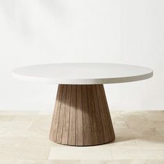 a round white table sitting on top of a tiled floor