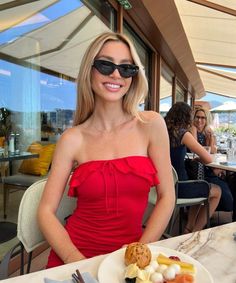 a woman sitting at a table with food on it