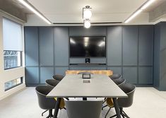 an empty conference room with chairs and a flat screen tv mounted on the wall above it