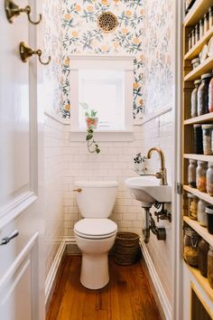 a white toilet sitting in a bathroom next to a window