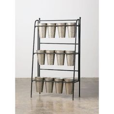 a metal shelf with several buckets on it and one is holding cups in the middle