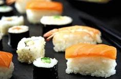 sushi is displayed on a black tray