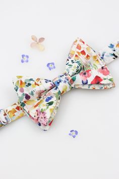 a colorful bow tie laying on top of confetti scattered around it's sides