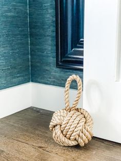 a rope ball sitting on top of a wooden floor in front of a wall mounted mirror