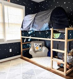 a child's bedroom with a bunk bed and space themed wallpaper on the walls