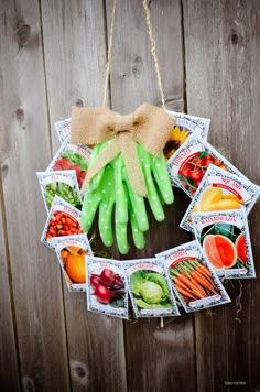 a wreath hanging on the side of a wooden fence with pictures of fruits and vegetables