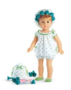 a doll and its accessories are shown on a white background, including a green hat