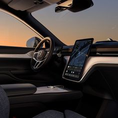 the interior of a car with an electronic device in the center console and steering wheel