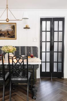 a dining room table with chairs and a bench in front of an open glass door