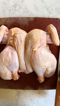 raw chicken sitting on a cutting board next to a knife