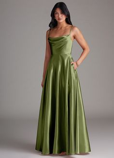 a woman in a long green dress posing for the camera with her hands on her hips