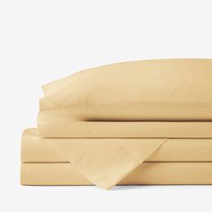 the sheets and pillowcases are folded neatly on top of each other in beige