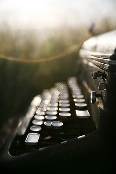 an old fashioned typewriter with the sun shining in the background