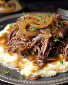 a plate topped with mashed potatoes covered in beef and gravy