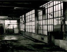 black and white photograph of an empty building with lots of windows on the side of it