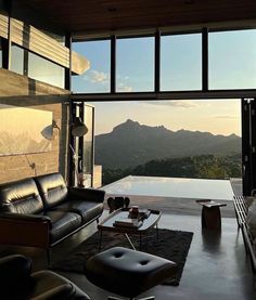 a living room filled with furniture next to a large glass window overlooking the mountain range