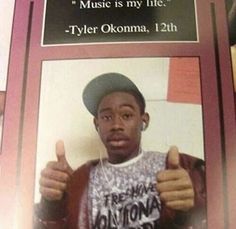 a man is giving the thumbs up in front of a sign that says music is my life - tyler okomaa, 12th