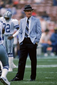 a man in a suit and tie standing on the sidelines