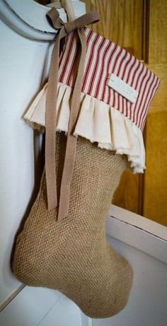 a christmas stocking hanging on the wall next to a wooden door with a ribbon