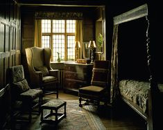 an old fashioned bedroom with wooden paneling and furniture in the dark, lit room