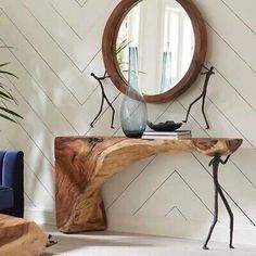 a wooden table sitting in front of a mirror on top of a white tiled floor