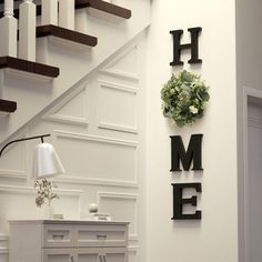 a living room with white walls and stairs