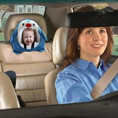 a woman sitting in the back seat of a car next to a child's head