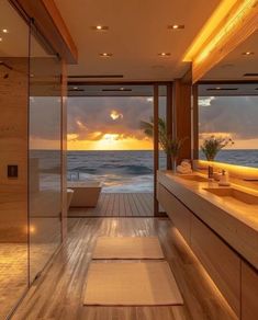 a bathroom with wooden floors and large windows overlooking the ocean