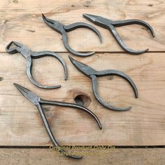 four pairs of scissors are sitting on a wooden table with holes in the handles and sides