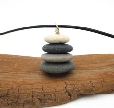 Bring back memories of that summer trip or day at the lake with this one-of-a-kind pendant necklace. Simple, earthy, and natural describe this beautiful miniature cairn necklace made from stones collected from beaches along Lake Michigan's golden coast. This necklace features four pebble stones worn smooth by the timeless action of Lake Michigan's sand and waves and would be the perfect gift for your special someone.  Thousands of years in the making, these stones were picked by myself from the surf for their shape, smoothness, color, and pattern. The four pebbles together measure 3/4 inch tall by 3/4 inch wide at the base and weigh only 0.2 ounces. The piece is completed with a 22-inch, naturally dyed black leather cord and sterling silver ball pin and findings. Along with your order, you Cairn Necklace, Golden Coast, Pebble Pendant, Pendant Necklace Simple, Pebble Stone, Summer Trip, Stacked Stone, Small Gift Boxes, Necklace Simple