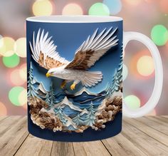 a coffee mug with an eagle flying over the mountains and trees on it's side