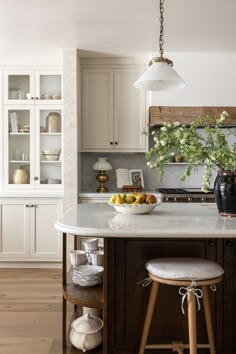 a bowl of fruit is on the kitchen island