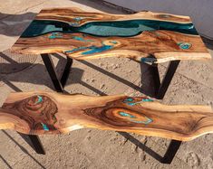 two tables made out of wood with blue glass in the center and black metal legs