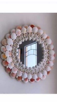 there is a mirror made out of seashells on the wall