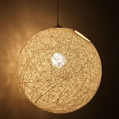 a light that is hanging from the ceiling with some wires attached to it, in a dark room