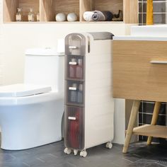 a bathroom with a toilet, sink and shelving unit next to the bathtub