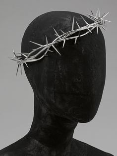 a black mannequin head with a crown of thorns on it