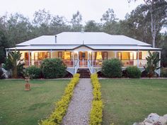 a white house sitting on top of a lush green field