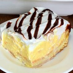 a piece of cake on a white plate with chocolate drizzled on top