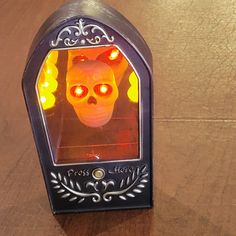 a skull shaped light up mirror on top of a wooden table