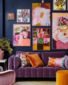 a living room filled with purple couches and paintings