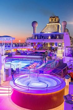 an outdoor swimming pool on the deck of a cruise ship at night with colorful lights